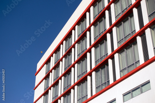 White, modern hotel exterior wall and windows with a clear blue sky in the background photo