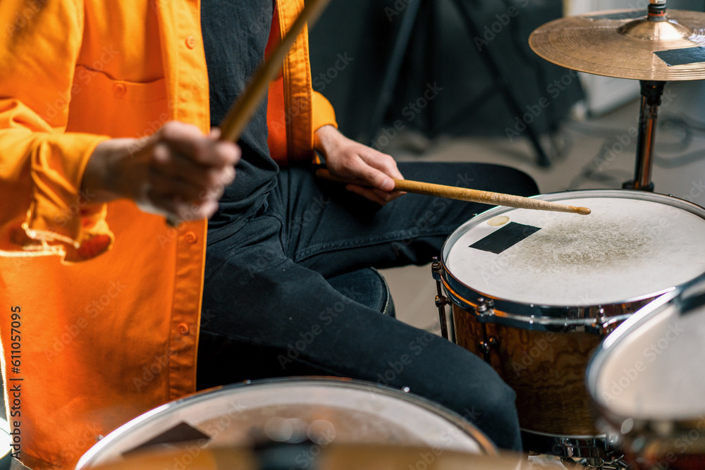 Fototapeta premium a young male drummer plays a drum kit in a recording studio at a professional musician's rehearsal recording a song