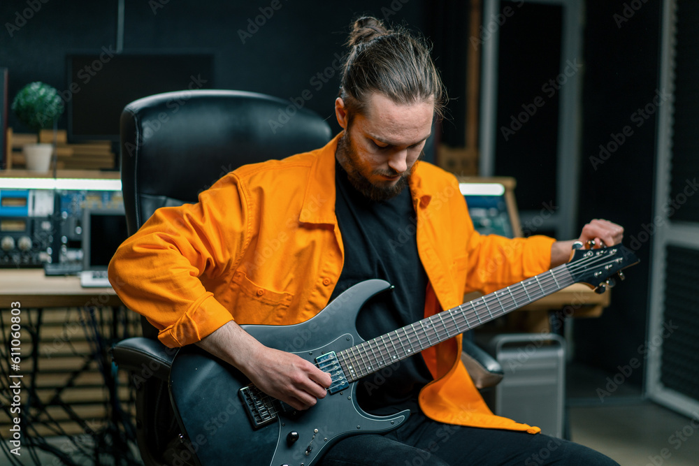 Obraz premium rock performer with electric guitar in recording studio recording playing own track musical instrument strings melody