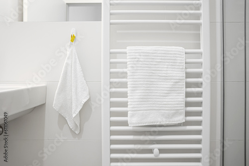 Obraz na plátně Heated towel rail near light wall in bathroom