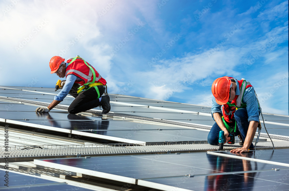 Engineer working setup Solar panel at the roof top. Engineer or worker work on solar panels or solar cells on the roof of business building Engineer working setup Solar panel at the roof top. Engineer or worker work on solar panels or solar cells on the roof of business building