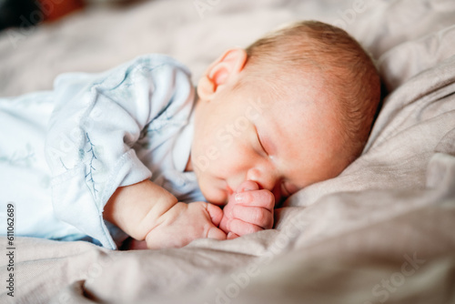 Little newborn baby boy sleeping in the bed