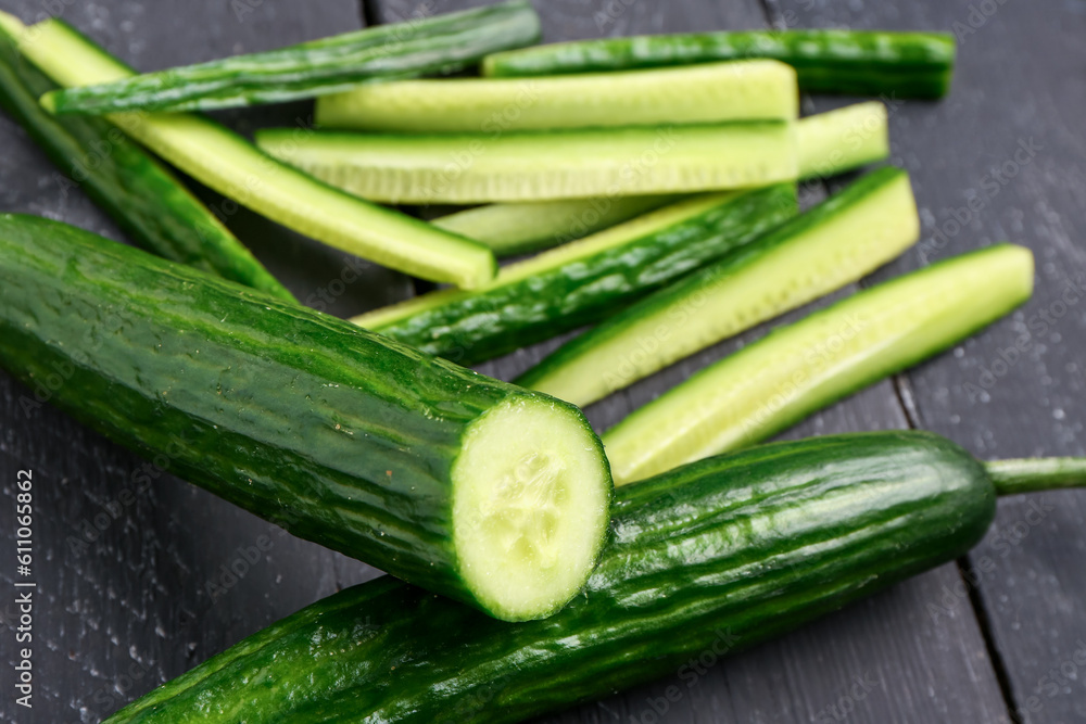 Fresh cut cucumbers on dark wooden background, closeup Fresh cut cucumbers on dark wooden background, closeup
