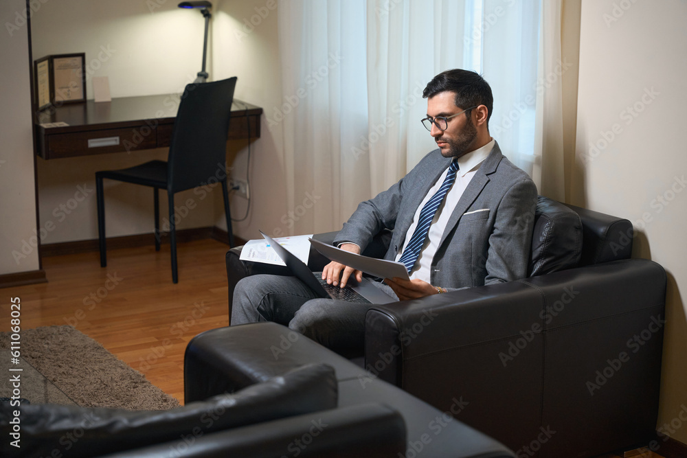 Fototapeta premium Businessman in business suit is studying working documents in relax zone