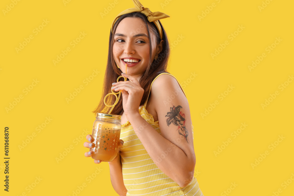 Young woman with glass jar of vegetable juice on yellow background Young woman with glass jar of vegetable juice on yellow background