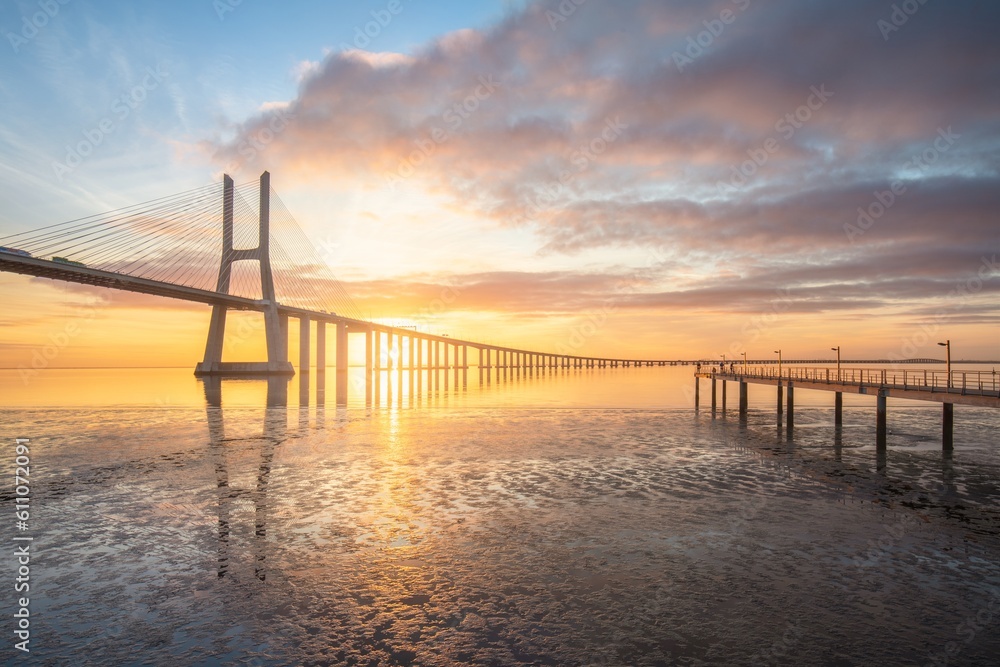 Vasco da Gama bridge in Lisbon by sunrise, Portugal. The Vasco da Gama Bridge is a landmark, and one of the longest bridges in the world. Urban landscape. Portugal is an amazing tourist destination