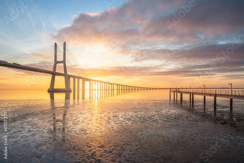 Vasco da Gama bridge in Lisbon by sunrise, Portugal. The Vasco da Gama Bridge is a landmark, and one of the longest bridges in the world. Urban landscape. Portugal is an amazing tourist destination © Michal