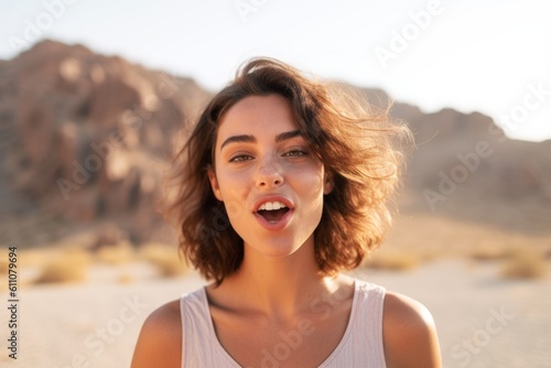 Close-up portrait photography of a grinning girl in her 30s sending blowing kiss against a picturesque desert oasis background. With generative AI technology