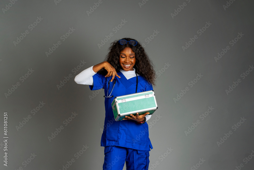happy african nurse holding a first aid box isolated in a white background happy african nurse holding a first aid box isolated in a white background