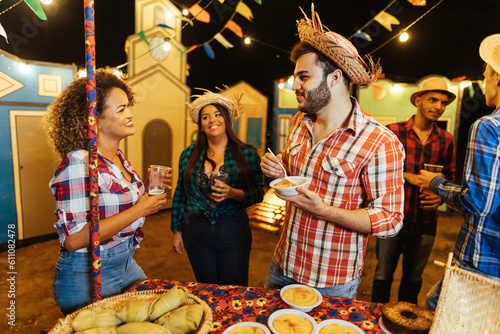 Festa Junina. Group of friends gathered at the typical food table. photo