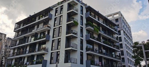 Beautiful modern multi-storey building in a new area of the city. Lots of green plants on the balconies.