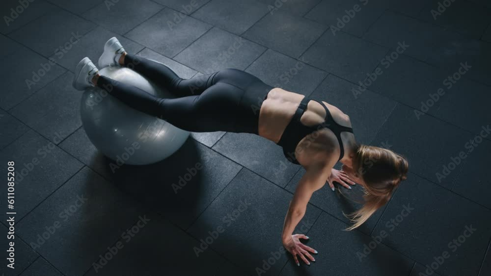 athletic young woman in black sportswear training abs with exercice ball, aerobic exercise in gym. slow motion. top view. High quality 4k footage