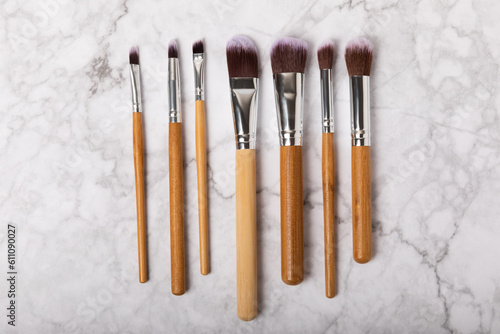 Cosmetic makeup brush on a white marble background. Professional makeup brushes. Eyeshadow, blush, foundation and contouring brushes. Makeup tool. Visagiste. Place for text.Copy space