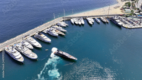 Aerial drone photo of small luxury yacht manoeuvring to dock in Mediterranean port with anchored yachts © aerial-drone