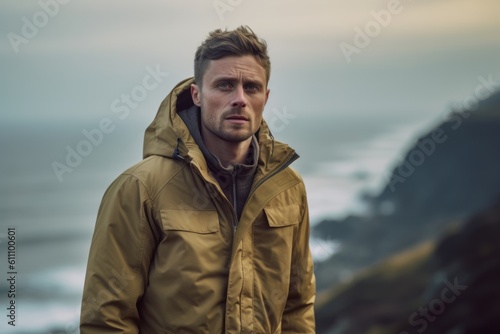 Medium shot portrait photography of a satisfied boy in his 30s wearing a warm parka against a scenic ocean cliff background. With generative AI technology