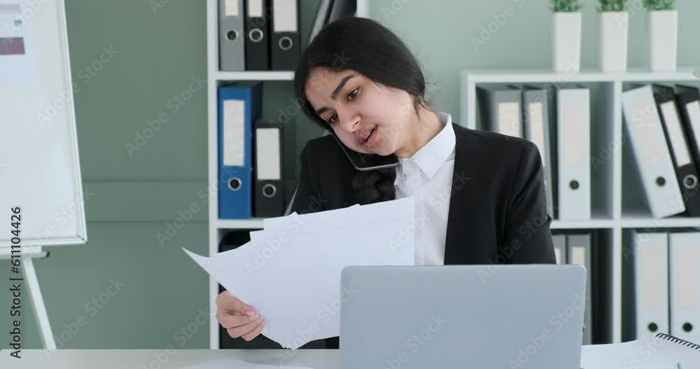 Indian businesswoman is fully occupied with her work responsibilities. Engrossed in a phone conversation, she skillfully communicates while handling important work matters. Indian businesswoman is fully occupied with her work responsibilities. Engrossed in a phone conversation, she skillfully communicates while handling important work matters.