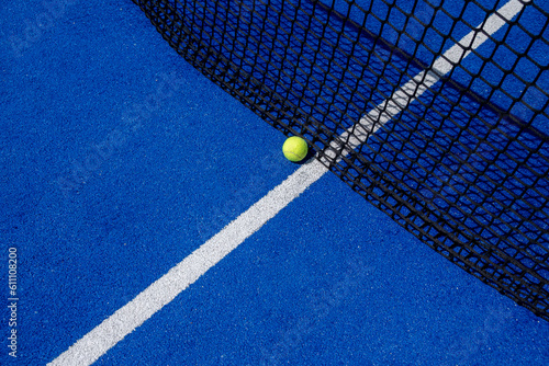 ball close to the net on a blue paddle tennis court © Vic