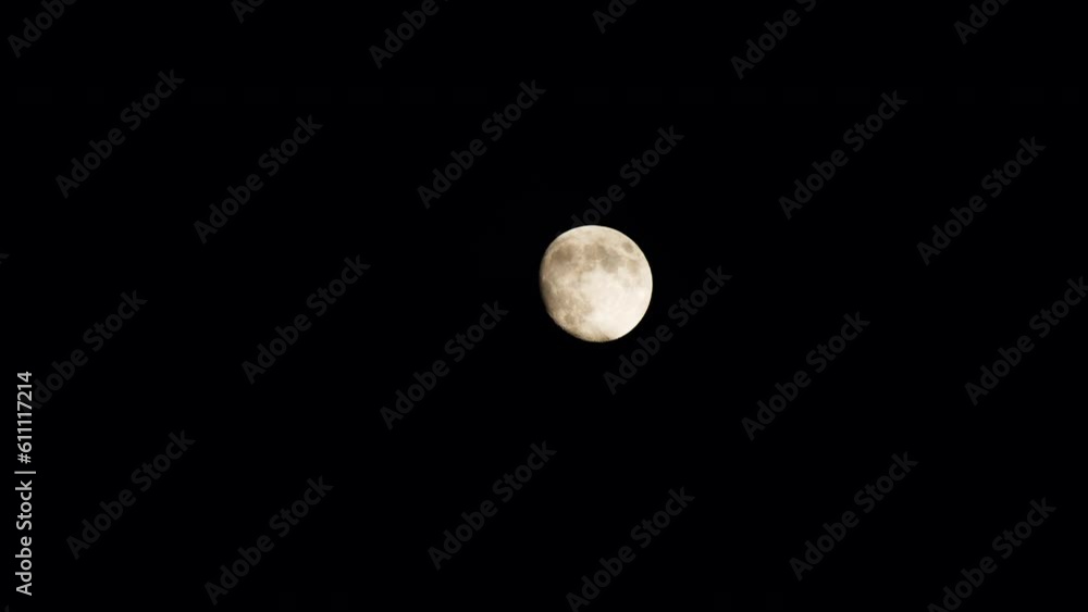 The full clear moon is gradually completely covered by black ominous clouds. A beautiful moonlight night is interrupted by an oncoming storm. Close-up. The full moon slowly drifts behind black clouds. The full clear moon is gradually completely covered by black ominous clouds. A beautiful moonlight night is interrupted by an oncoming storm. Close-up. The full moon slowly drifts behind black clouds.