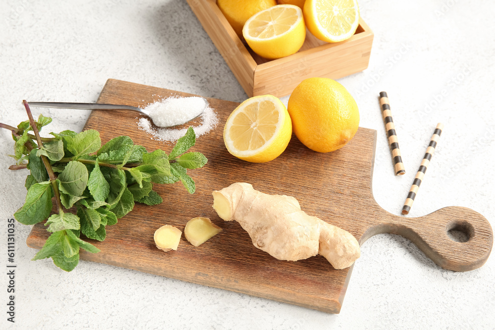 Fototapeta premium Wooden board and box with ingredients for preparing lemonade on grunge white background
