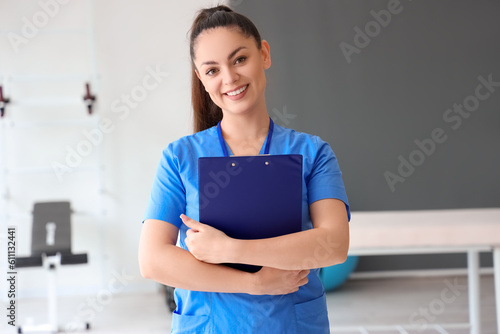 Female physiotherapist with clipboard in rehabilitation center