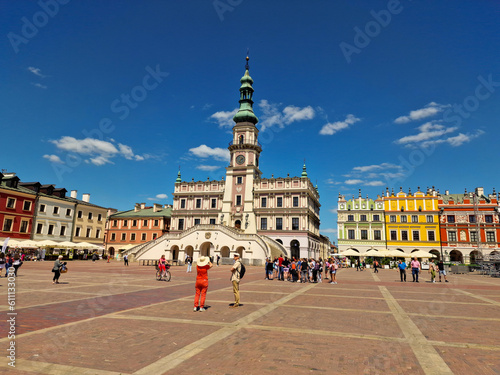 tourists visitors main market square in the Old Town. Town Hall in Zamosc. Poland