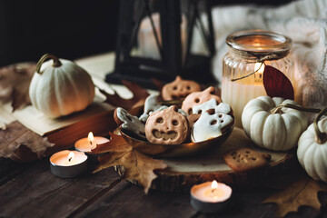 Homemade halloween holiday treats for kids. Gingerbread cookies on wooden board, decorated with pumpkins and autumn leaves. Cozy fall home atmosphere