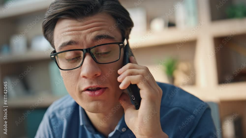Eyeglasses man talking cellphone office closeup. Freelancer enjoying phone call Eyeglasses man talking cellphone office closeup. Freelancer enjoying phone call