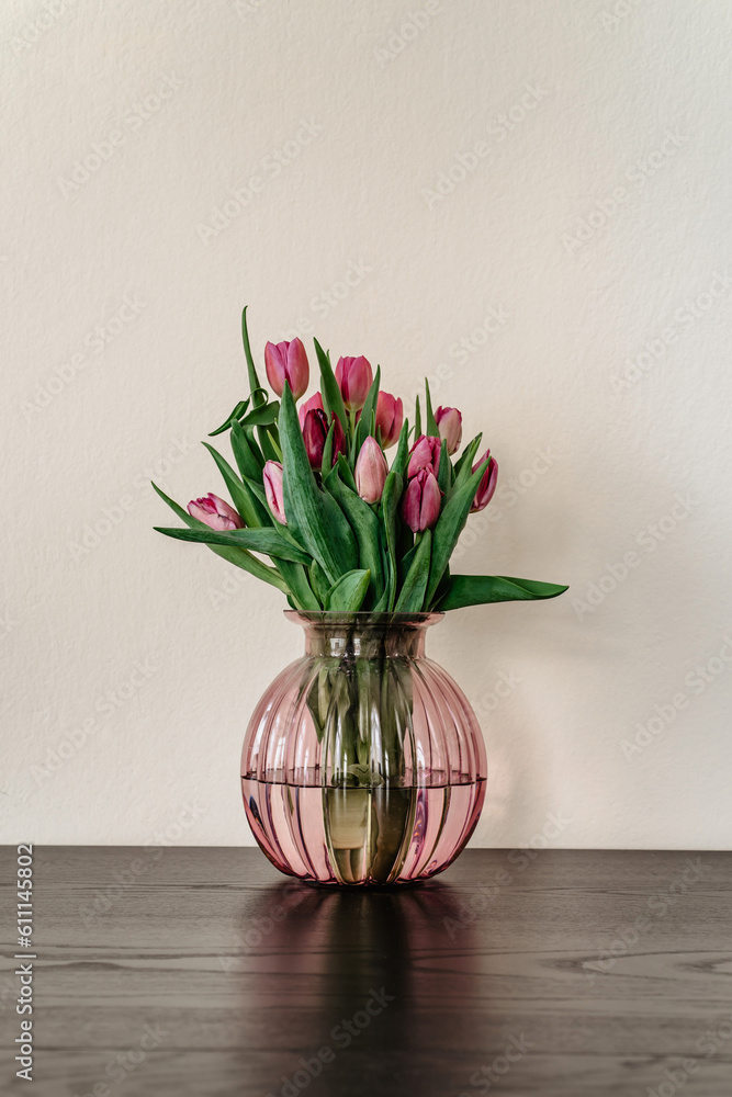 Beautiful spring decoration.Pink purple tulips in glass vase.Fresh tulip flowers bouquet.View with copy space.Greeting card.Woman Mothers Day.Minimalistic bouquet of flowers.Home decoration