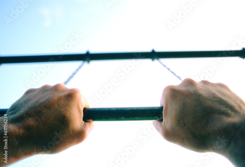 Hands on trapeze bar looking to sky. photo