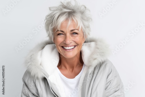 Headshot portrait photography of a grinning mature woman making a i'm cold gesture by hugging oneself against a white background. With generative AI technology