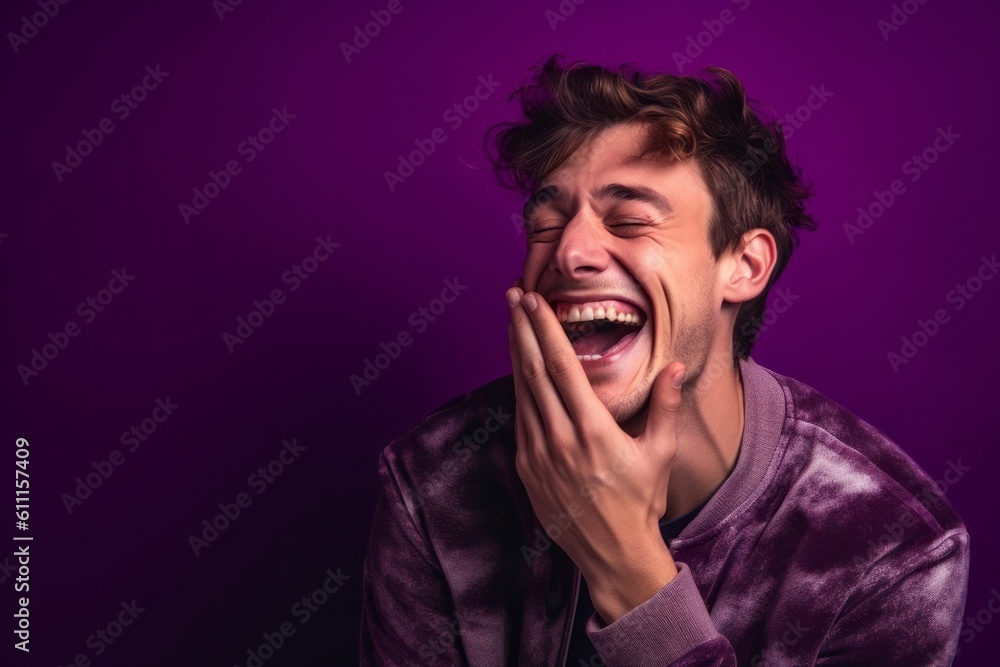Fototapeta premium Close-up portrait photography of a satisfied boy in his 30s placing the hand over the mouth in a laughter gesture against a vibrant purple background. With generative AI technology