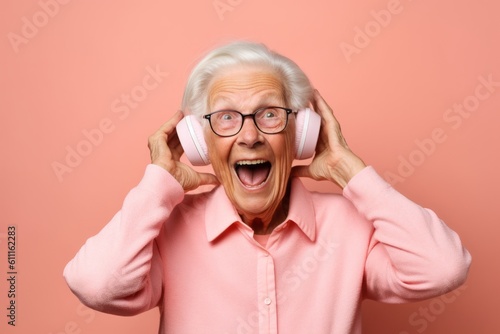 Headshot portrait photography of a happy old woman covering one's ears against a salmon pink background. With generative AI technology