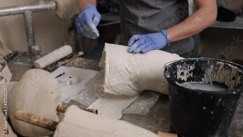 Workspace professionalism, Prosthetic design, Mold creation. Plaster representation of prosthetic leg mold for hip disarticulation being developed by man in professional workshop. photo