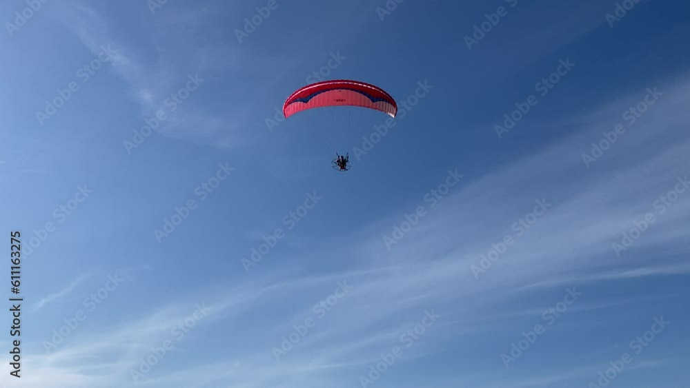 Sublime view in Porto San Giorgio at a red and blue paraglider soaring above the Adriatic Sea, camera tilting upwards from ground to sky, closely following the object until it moves out of the frame Sublime view in Porto San Giorgio at a red and blue paraglider soaring above the Adriatic Sea, camera tilting upwards from ground to sky, closely following the object until it moves out of the frame