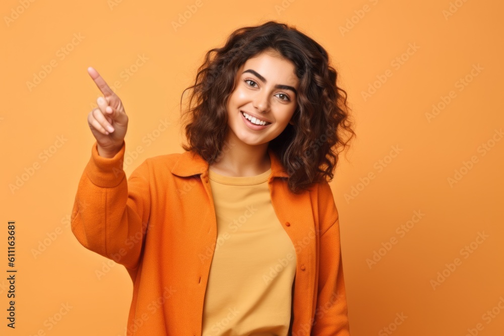 Medium shot portrait photography of a happy girl in her 20s pointing down against a pastel orange background. With generative AI technology Medium shot portrait photography of a happy girl in her 20s pointing down against a pastel orange background. With generative AI technology
