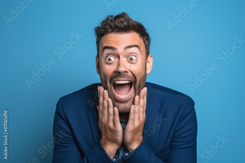 Medium shot portrait photography of a glad boy in his 30s placing the hand over the mouth in a laughter gesture against a periwinkle blue background. With generative AI technology © Markus Schröder