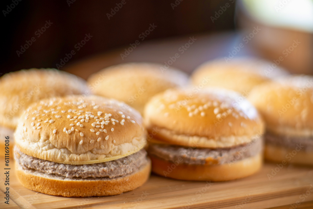Semi-finished cheeseburger, frozen hamburgers on a wooden background.