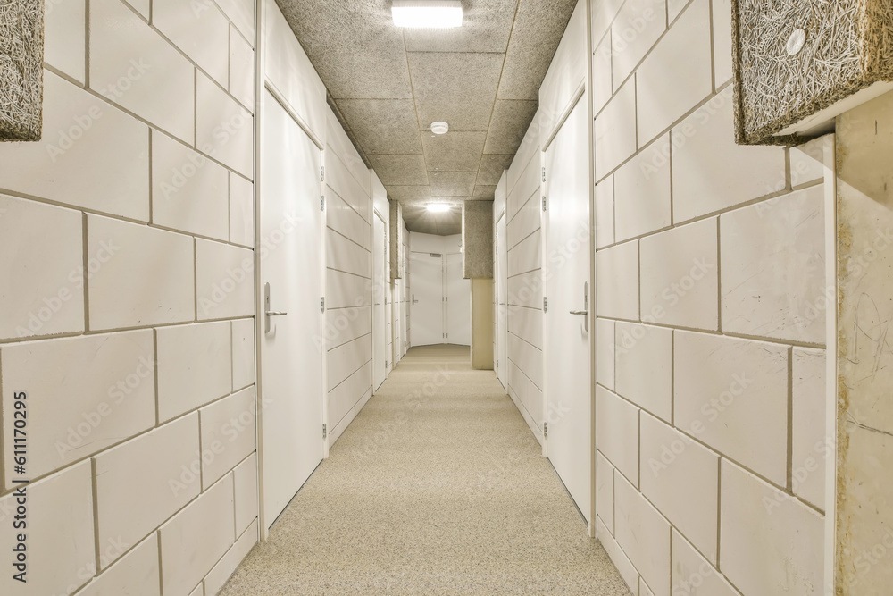 a long hallway with white tiles on the walls and flooring in an office building that is being used for storage