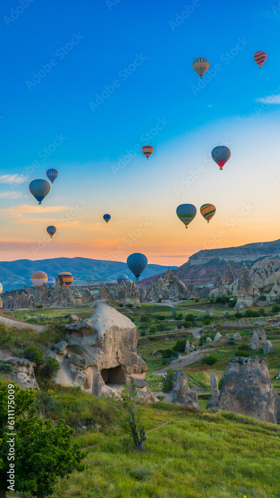 Cappadocia Turkey. Hot air balloons flying over fairy chimneys at sunrise in Cappadocia. Travel to Turkey. Touristic landmarks of Turkiye. Selective focus included.