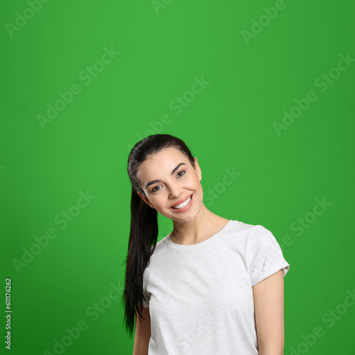 Chroma key compositing. Pretty young woman with dark hair against green screen