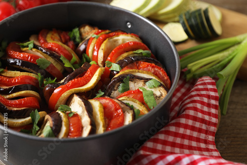 Delicious ratatouille in round baking pan on table, closeup