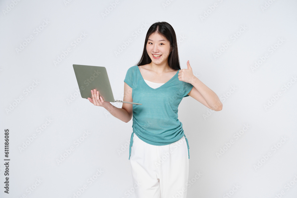 Young asian woman holding a laptop and showing thumbs up isolated on white background. Young asian woman holding a laptop and showing thumbs up isolated on white background.