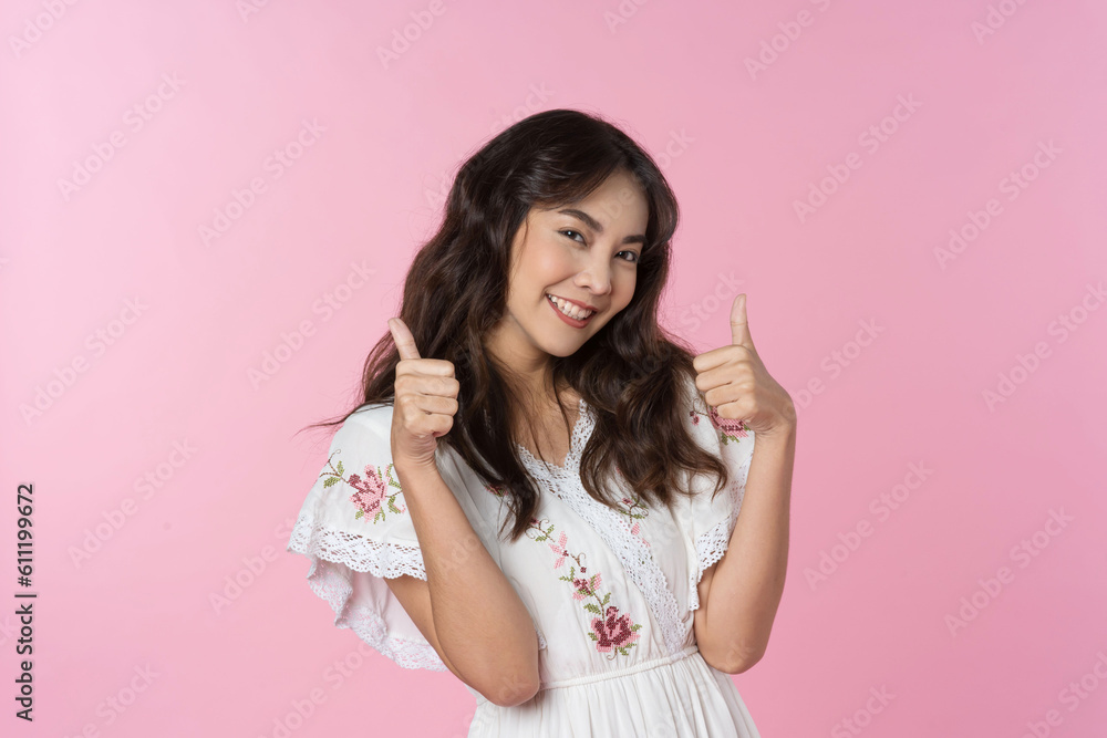 Young Asian woman showing two hands with thumbs up on isolated pink background Young Asian woman showing two hands with thumbs up on isolated pink background