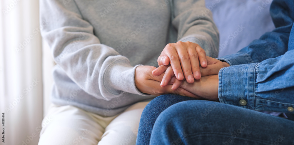 Closeup image of a couple women holding each other hands for comfort and sympathy Closeup image of a couple women holding each other hands for comfort and sympathy