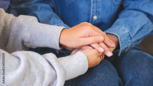 Closeup image of a couple women holding each other hands for comfort and sympathy