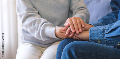 Closeup image of a couple women holding each other hands for comfort and sympathy