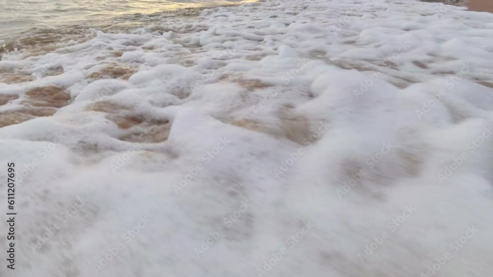Sea waves crashing onto sandy beach in the late afternoon sun, slowmo. Sea waves crashing onto sandy beach in the late afternoon sun, slowmo.