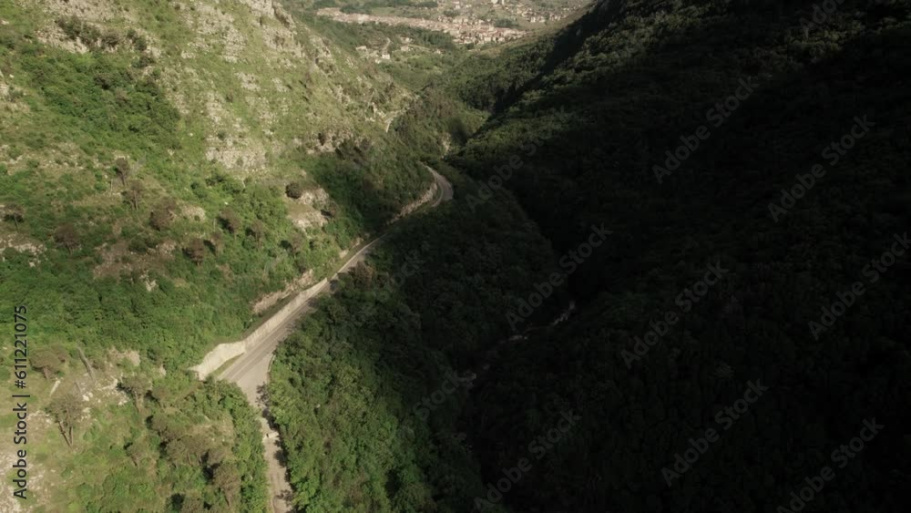 Forward aerial view of a road in the valley into mountains leading to a village. Italy Forward aerial view of a road in the valley into mountains leading to a village. Italy