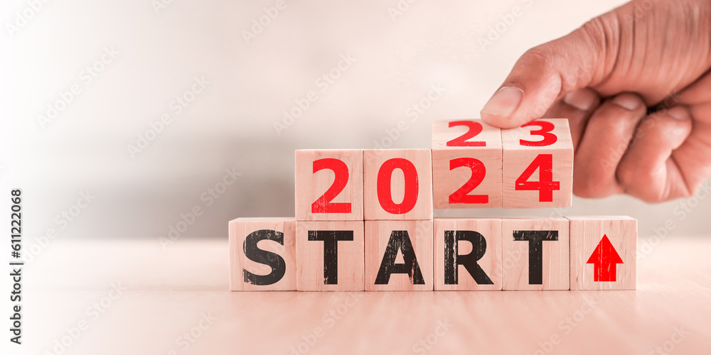 2024 start concept. Hand flip wood cube change year 2023 to 2024 Stock