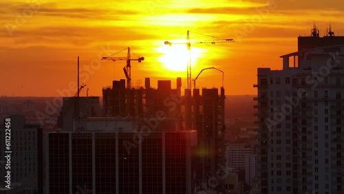 Aerial view of new developing residense in american urban area at sunset. Tower cranes at industrial construction site in Miami, Florida. Concept of housing growth in the USA photo